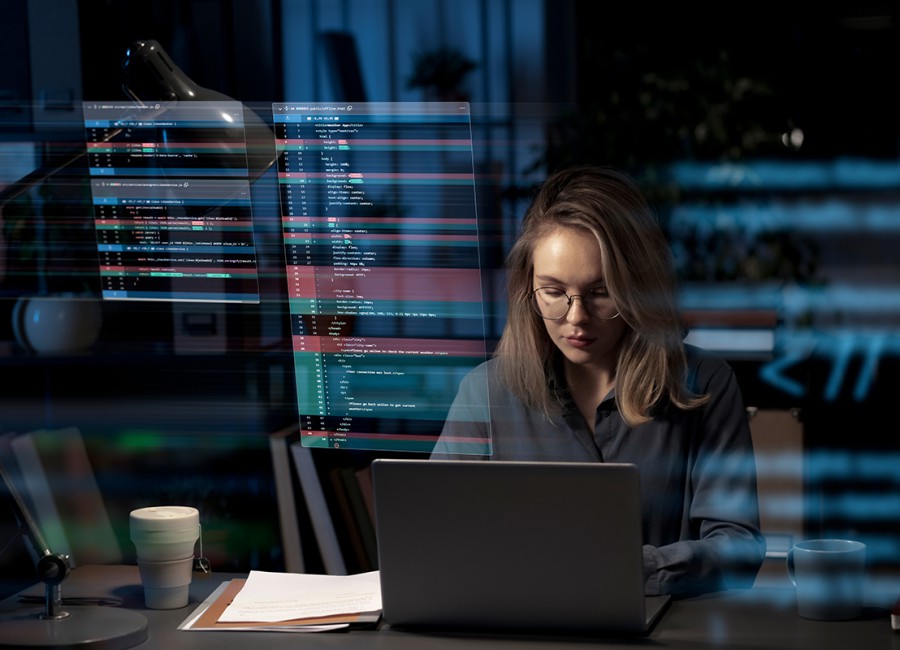 Femme travaillant sur un ordinateur portable avec des interfaces de code en surimpression