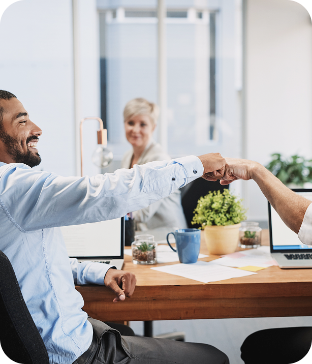 Collègues se saluant par un check main dans un bureau