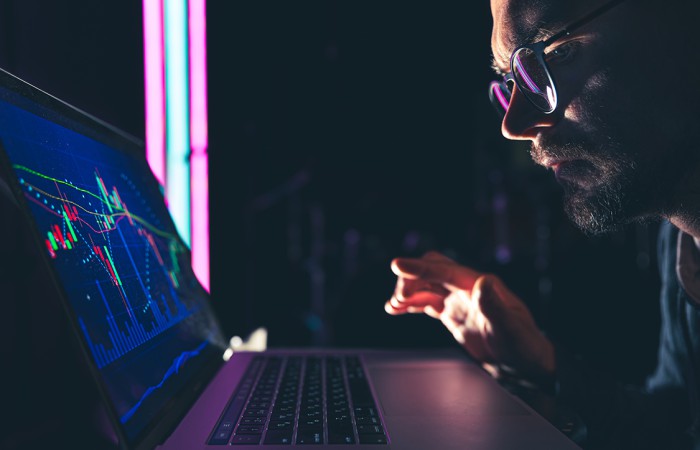 Analyste consultant surveillant des graphiques de sécurité sur un ordinateur portable